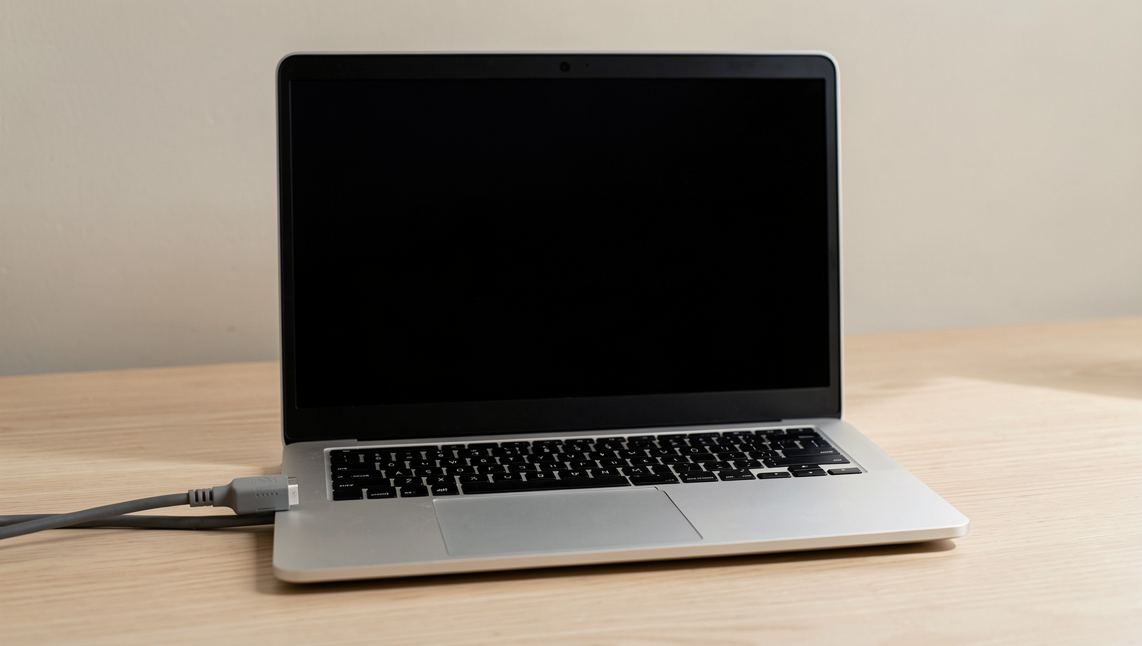 Laptop connected to power outlet, demonstrating operation without battery.